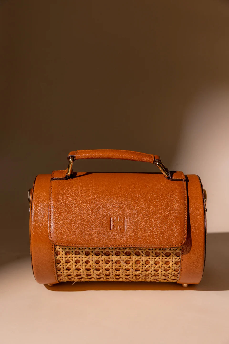 Tan Solihiya Rollers Regular bag photographed in warm light against a beige backdrop.