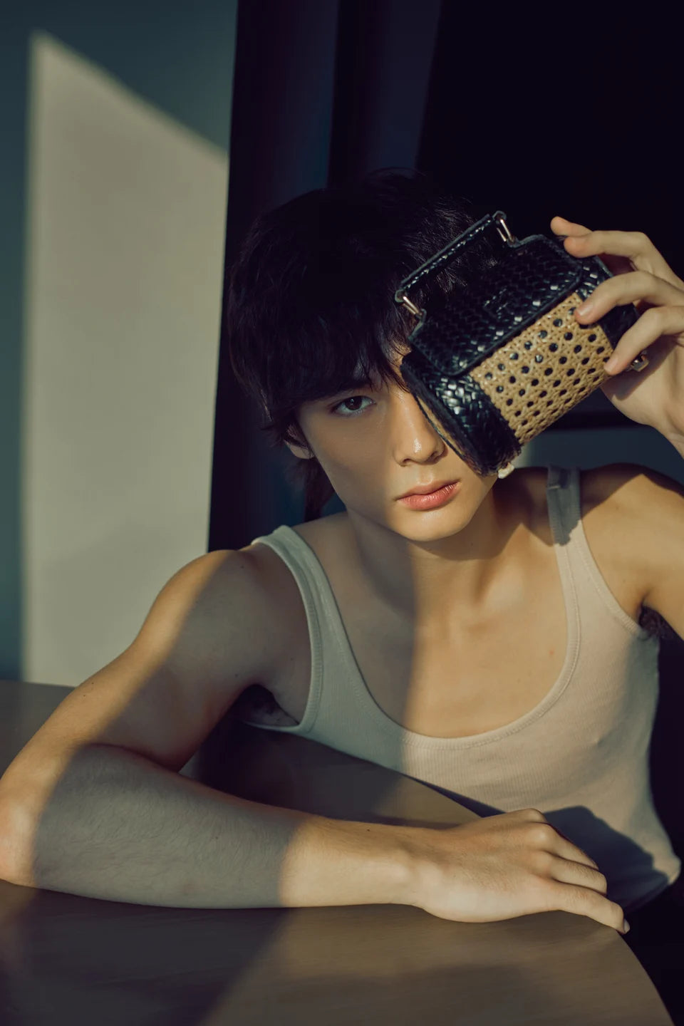 A black Solihiya Roller bag held beside a model’s face